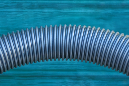 one long gray plastic hose against green wooden wallの写真素材