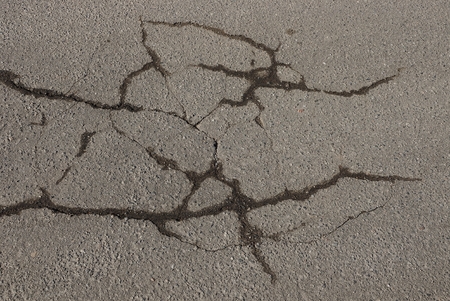 gray asphalt stone texture on a cracked roadの写真素材