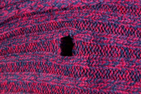 red woolen fabric texture with a hole