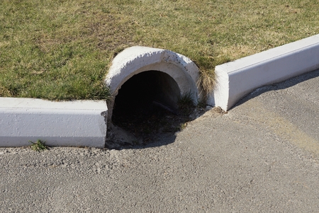 concrete sewer pipe on green lawn with green grass