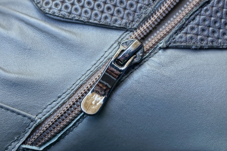 black metal zip on a gray leather surfaceの写真素材