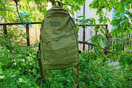 one large military backpack hanging in greenの写真素材