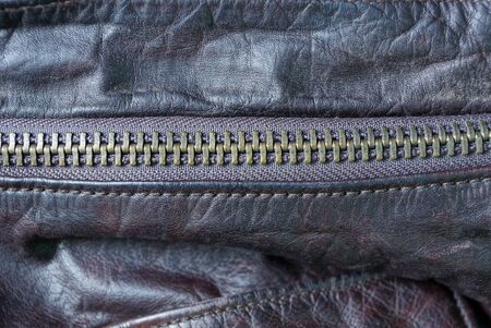 metallic zip on a piece of crumpled brown leather clothing