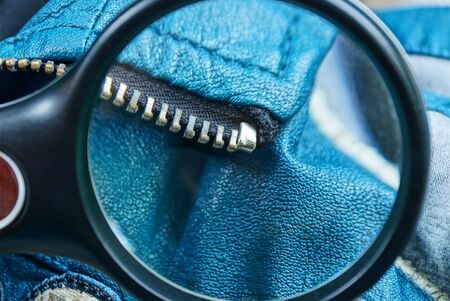 metal magnifier increases metal zip on blue leather clothesの写真素材