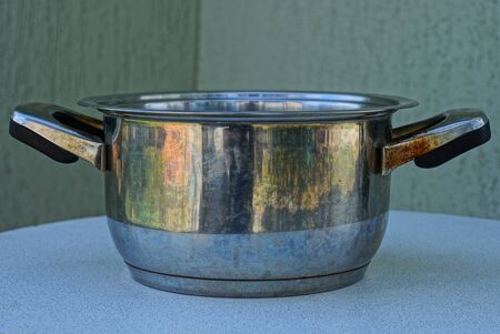 gray open metal pan stands on a white tableの写真素材