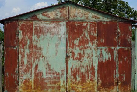 old colored metal garage with closed gates on the streetの写真素材