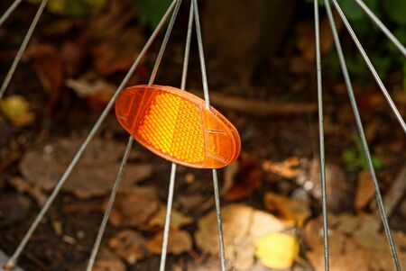 one red plastic reflector on gray metal wheel spokes