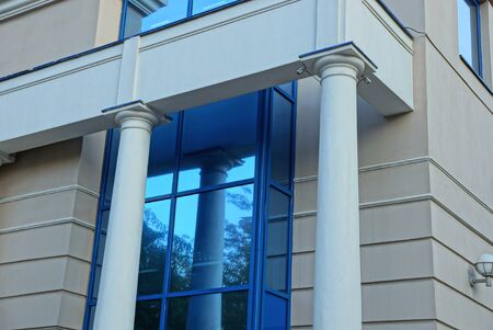 one large blue window on a gray concrete wall with columns