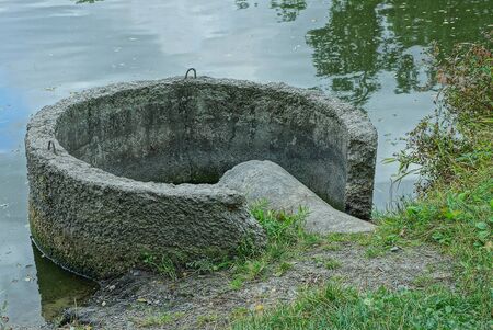 old gray concrete dam in lake water near the shoreの写真素材