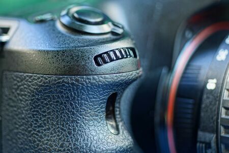 part of a black camera with a plastic handle, button and roller