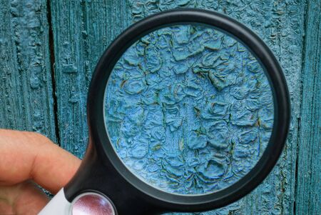 black magnifier enlarges the blue wall in cracked paintの写真素材