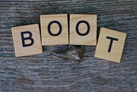 word boot made of wooden letters on a gray tableの写真素材