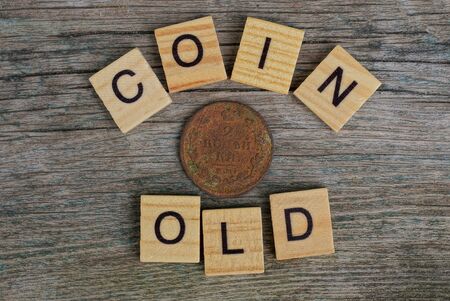word made of wooden letters and old brown coinの写真素材