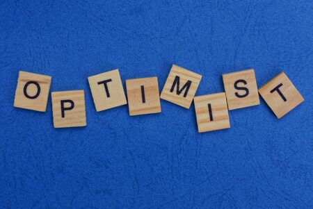 word optimist made of wooden letters on a blue tableの写真素材