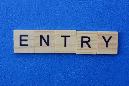 word entry made of brown wooden letters on a blue tableの写真素材
