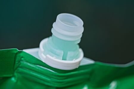 open white neck on a green plastic bag with a shampoo bottleの写真素材
