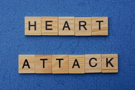 phrase heart attack made from brown wooden letters lies on a blue tableの写真素材
