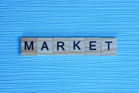 word market made of small wooden letters on a light blue paper backgroundの写真素材
