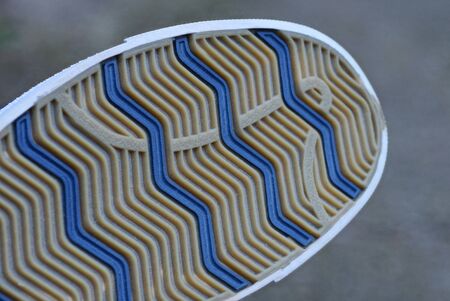 part of the boot with a rubber sole with a brown and blue pattern on a gray background