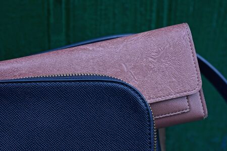 closed brown wallet lies in an open blue bag on a green backgroundの写真素材