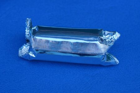 one white long foil bag lies on a blue table