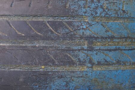 plastic background from black old dirty tire with blue paintの写真素材
