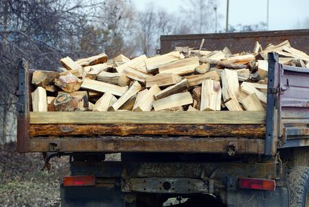 a pile of wooden firewood and logs in an iron truckの写真素材