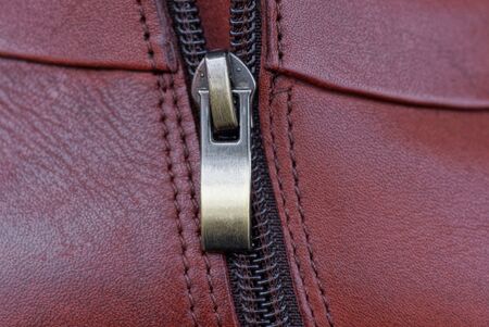 gray metal zip on red leather on a piece of clothingの写真素材