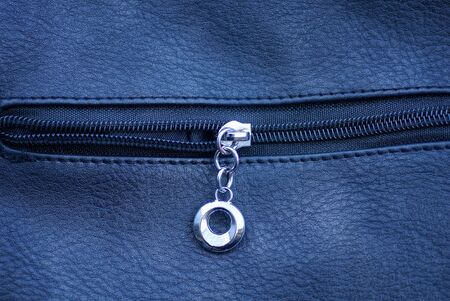 one gray metal zip on a black leather bag