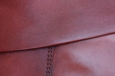 red brown background from a piece of leather with a seam