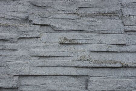 gray stone background of concrete and bricks in the fence wallの写真素材