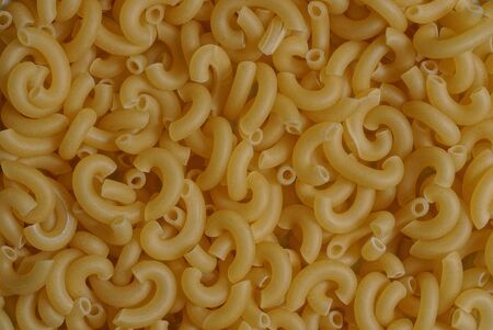 yellow natural background of dried small pasta in a heapの写真素材