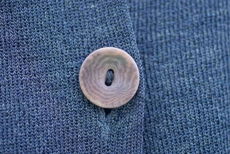 one old brown button on gray black fabric clothes