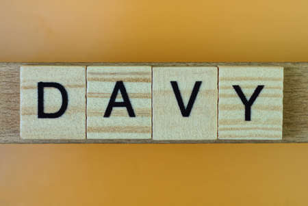 gray word davy made of wooden square letters on brown backgroundの写真素材
