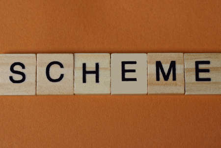 gray word scheme made of wooden square letters on brown backgroundの写真素材