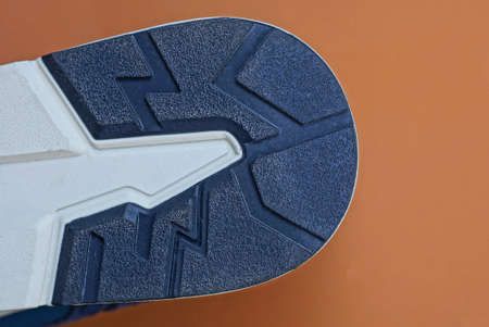 part of the sole on the shoe from a white black pattern on a brown background