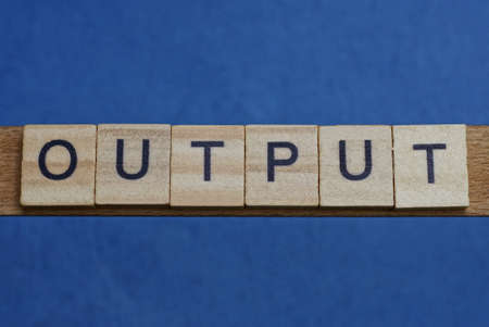 gray word output in small square wooden letters with black font on a blue background
