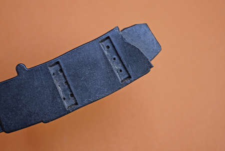 a piece of an old black broken plastic carabiner on a brown background
