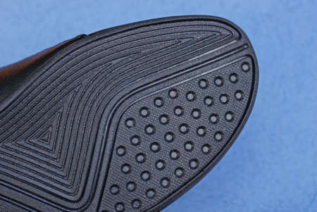 part of the boot with a rubber sole with a black pattern on a blue backgroundの写真素材