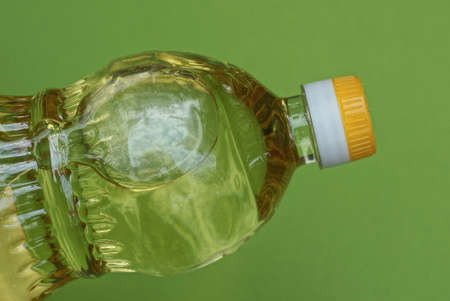one closed plastic bottle full of sunflower oil on yellow background