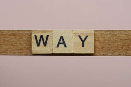 text the word way from gray wooden small letters with black font on an pink tableの写真素材