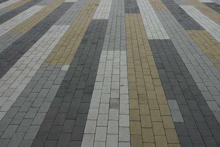 colored stone texture of bricks paving slabs on the alley of the road in the streetの写真素材