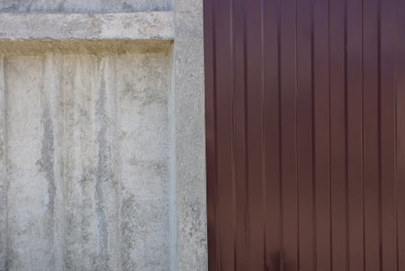 colored texture of gray concrete wall and brown metal fence outdoorsの写真素材