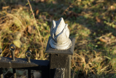 black iron decorative fence with a sharp one detail with a tip of gray metal