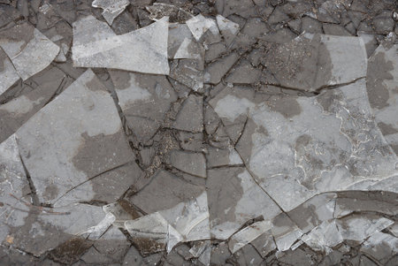 natural texture of gray dirty pieces of ice in a frozen puddle outside