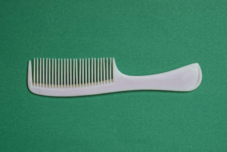one old gray plastic comb lies on a green tableの写真素材