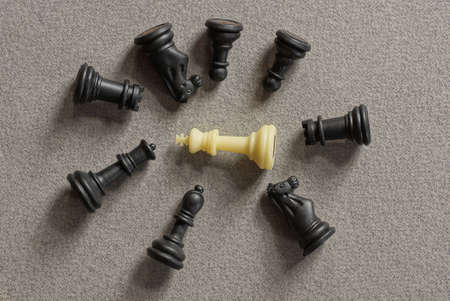 a pile of black and white chess figures lie on a gray table