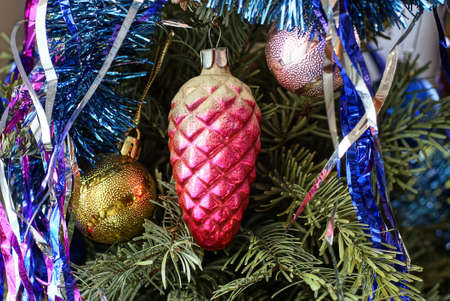 old red glass cone and round Christmas toys hang on green spruce branchesの写真素材