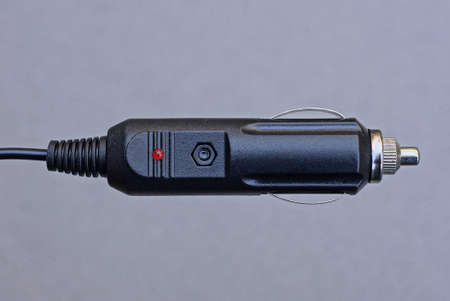 one long black car charger with a wire on a gray backgroundの写真素材