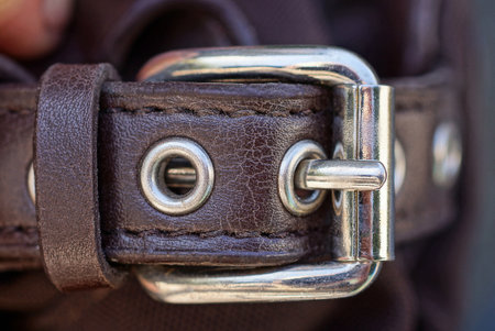 one metal white buckle on a brown leather harness bag strapの写真素材